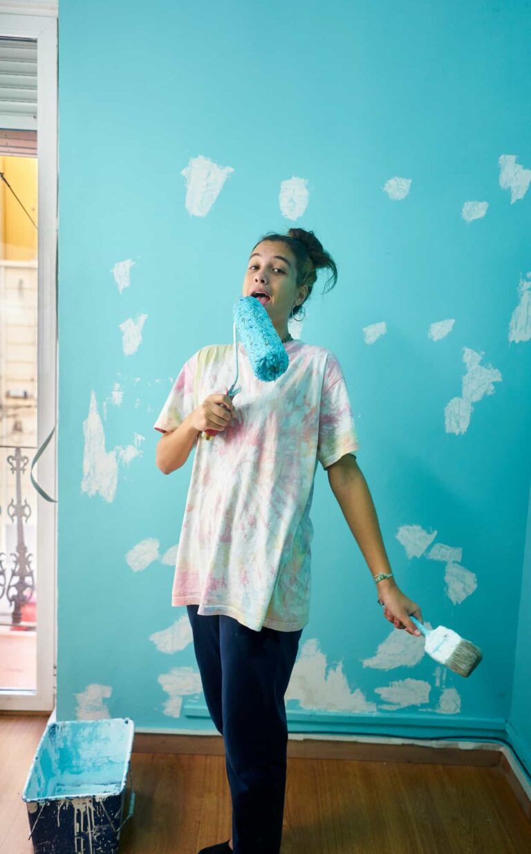 happy woman painting interior wall